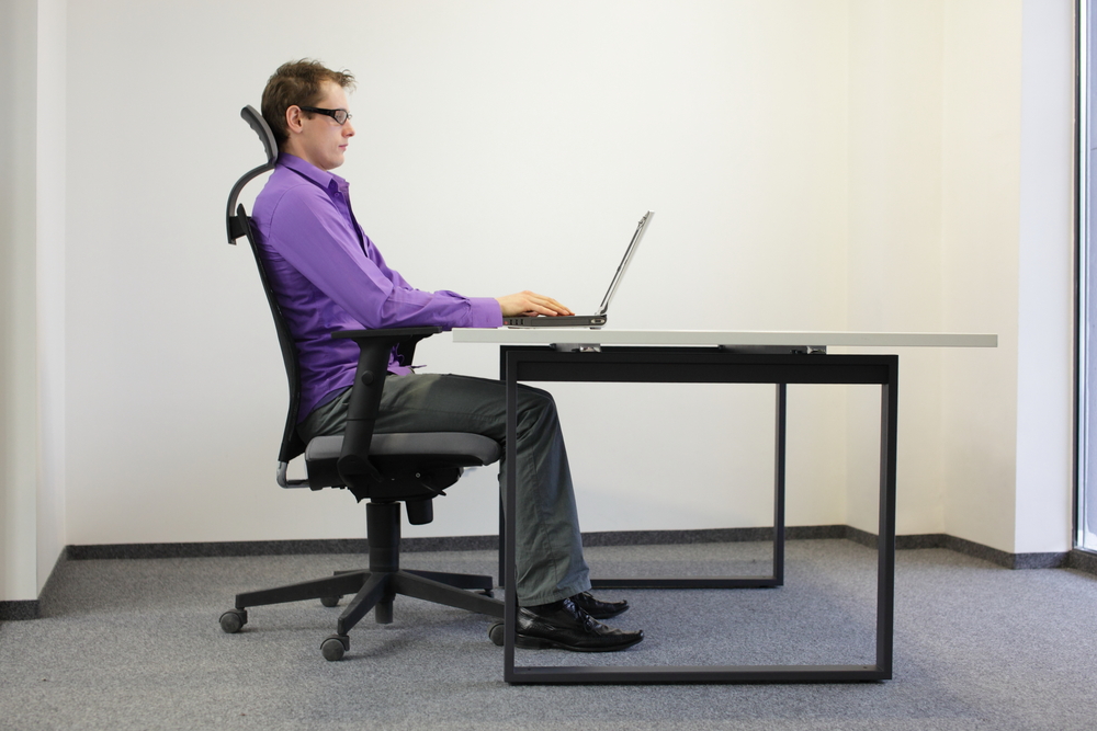 Mann sitzt im Büro vor einem Laptop