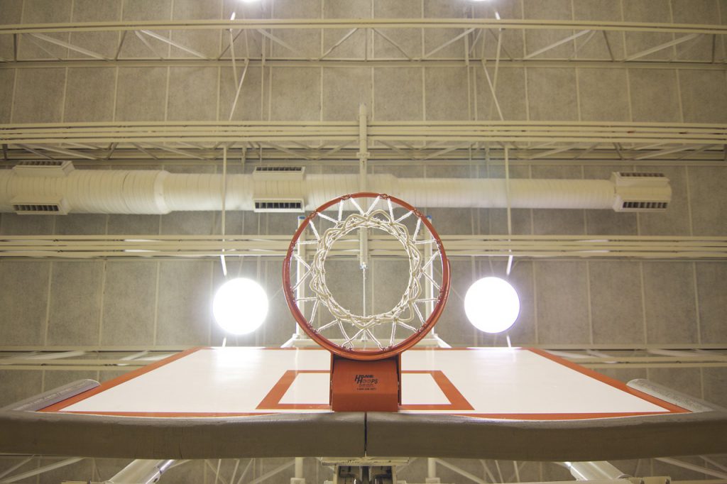 Basketballkorb von unten mit beleuchteter Decke.